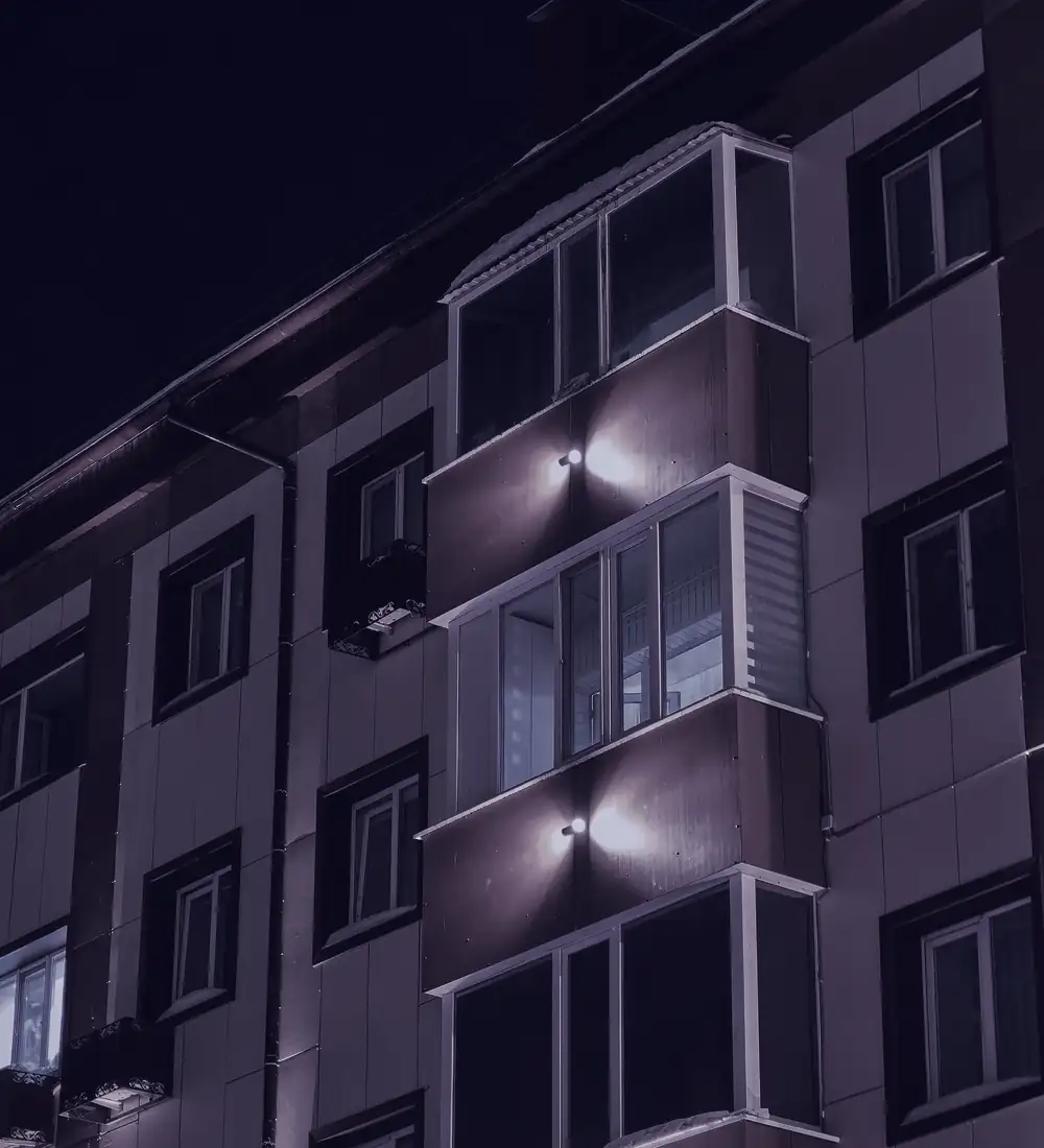 Large apartment complex with lit balconies at dusk